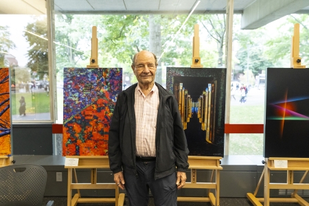Wally Gilbert stands in front of his aluminium prints in the Cabot Science Center.