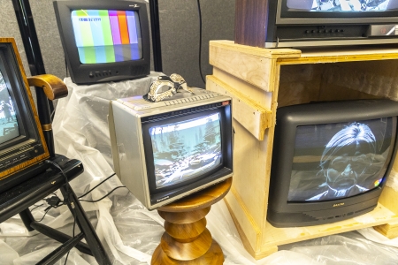 Several old TVs playing black and white images on the screen, while one has a No Signal screen.