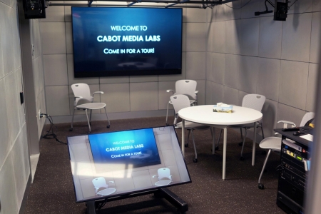 One of Cabot's media studios with chairs scattered around a table with a TV screen in the background