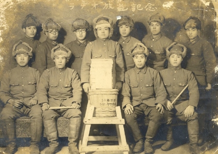 Japanese soldiers in uniform standing in rows and looking at the camera