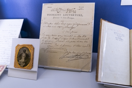 An exhibition case with a centerpiece item of a document signed by Toussaint L'overture.