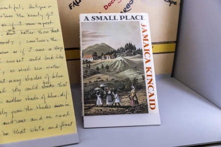 A copy of Jamaica Kincaid's A Small Place is displayed next to a notebook with handwritten text on it.