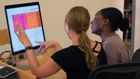 two students look at a computer screen