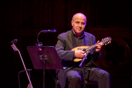 Heracles Zakkas sits on stage playing an instrument