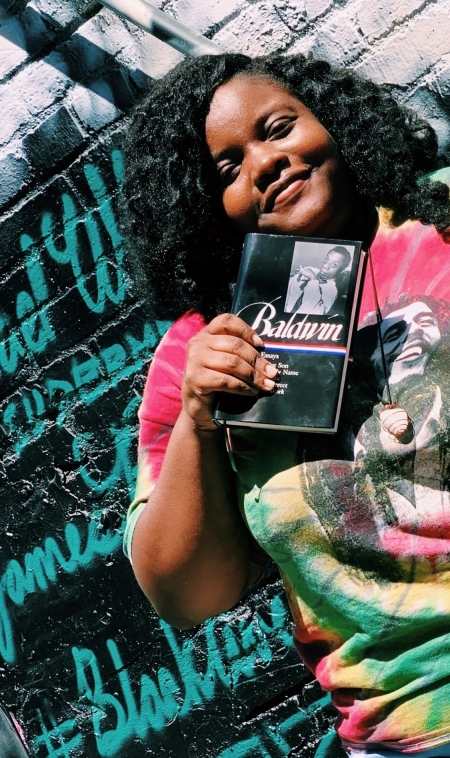 Woman holding book Collected Essays