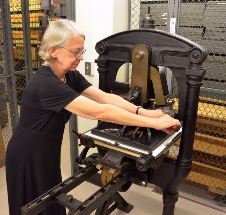 Instructor Hope Mayo operating the printing press.