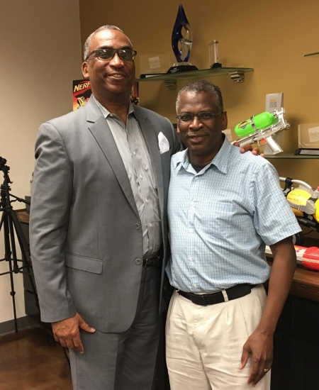 two professors stand side-by-side with their arm around each other