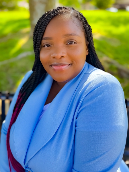 A portrait of a Black woman wearting a blue shirt