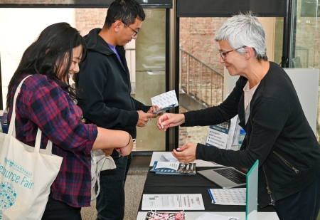 Two people check out resources at a table at a recent open access event.