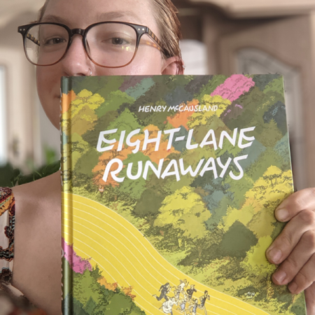 Woman holding book Eight Lane Runaways