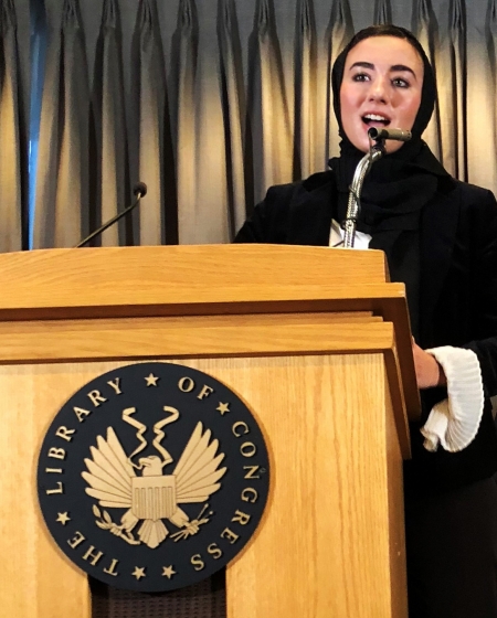 Hanaa Masalmeh stands at a Library of Congress podium and gives a speech