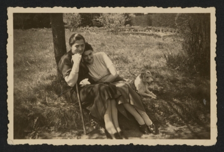 Mother and daughter sitting on the grass in a wood clearing