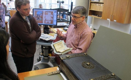 Large old book on table in front of people talking