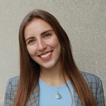 Tess Kelley, a white woman with brown hair, smiles at the camera.