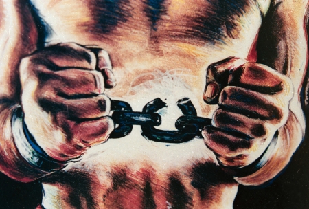 Mural depicting the torso of a man breaking free from chains around his wrists.