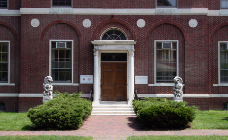 A brick building with a columned, double door entrance.