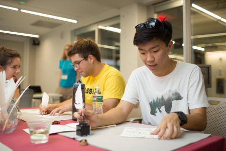 Student sitting, writing with a quill pen
