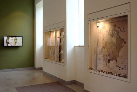 Exhibit at Tozzer Library with maps on the walls and nobody in the frame