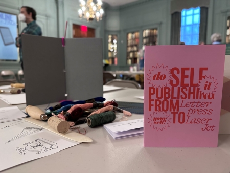 Materials for pamphlet and zine-making displayed with sign reading 'Do It Yourself: Self Publishing from Letterpress to Laserjet'