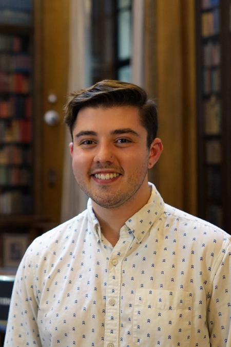 Nick Colón wears a collared shirt and smiles at the camera