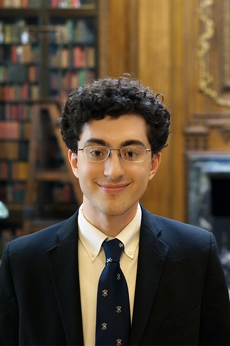 Richard Yarrow, wearing a blazer, tie, and glasses, smiles at the camera