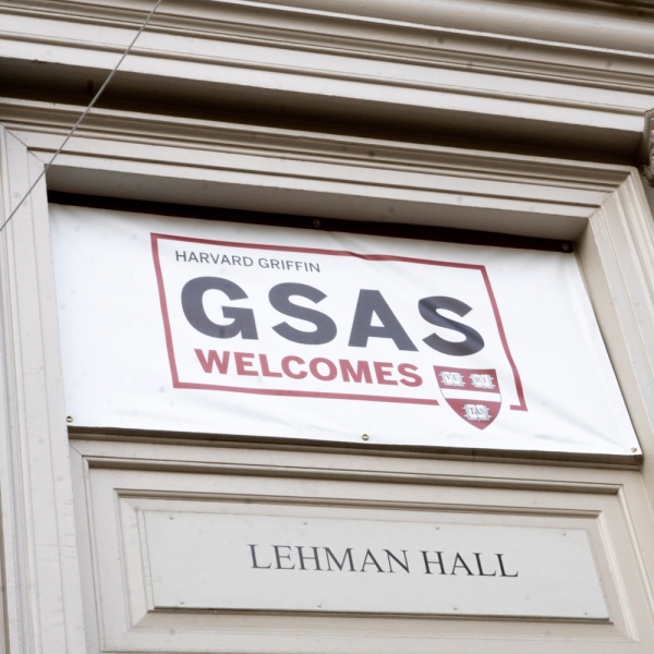 the facade of Lehman Hall with a sign that reads: "Harvard Griffin GSAS Welcomes"