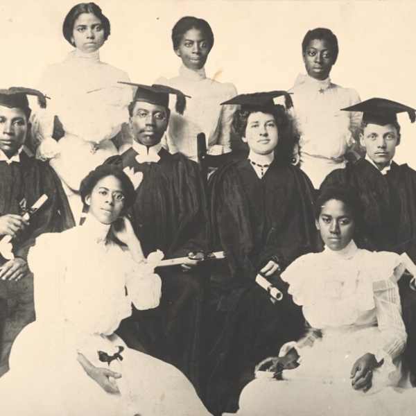 Black and white photo of 9 African American students posed in graduation attire