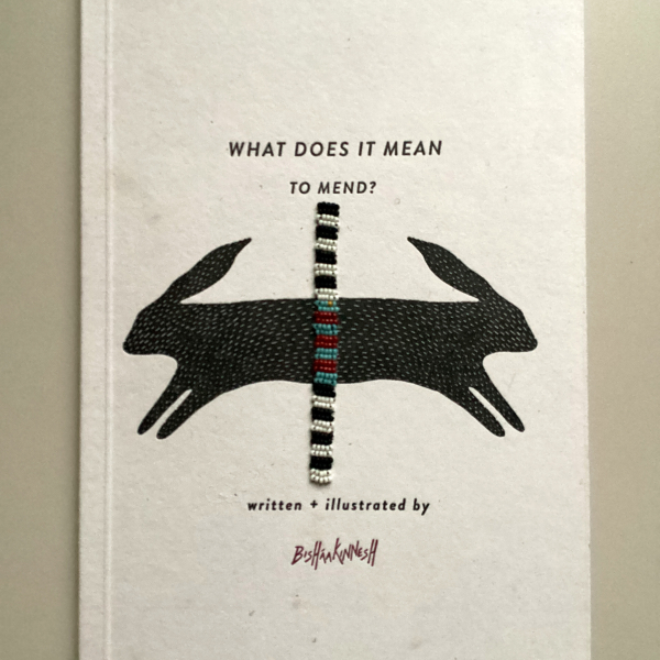 Photo of a book that includes an illustration of black rabbits and a beaded band