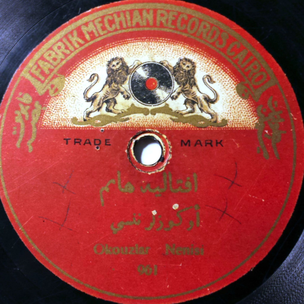 The label of a 78 rpm recording produced by Fabrik Mechian Records, Cairo, with a drawing of two lions rampant flanking a record.