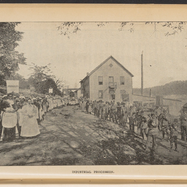 Image of a group of people along a road, with the caption "industrial procession"