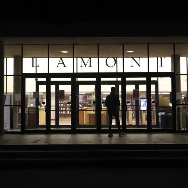 A view of Lamont Library's front door in the dark.