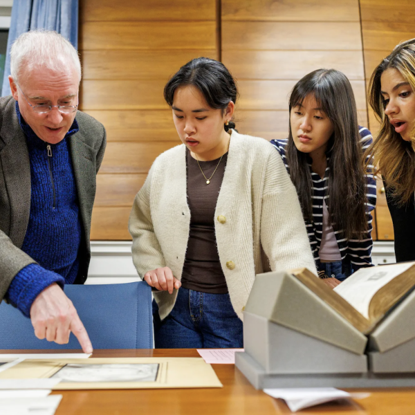 Professor David Armitage with students, looking at documents, at Houghton Library.