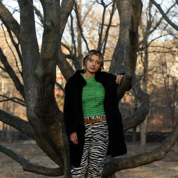 A young woman in front of a bare tree in the Arnold Arboretum.