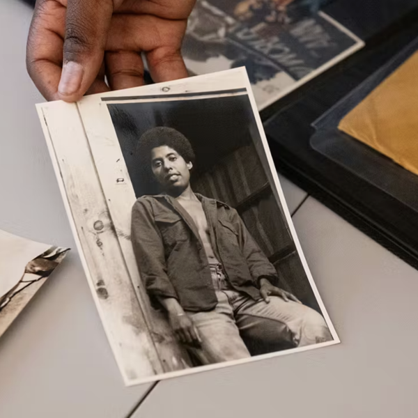 A hand holds a black and white photo of Barbara Smith.