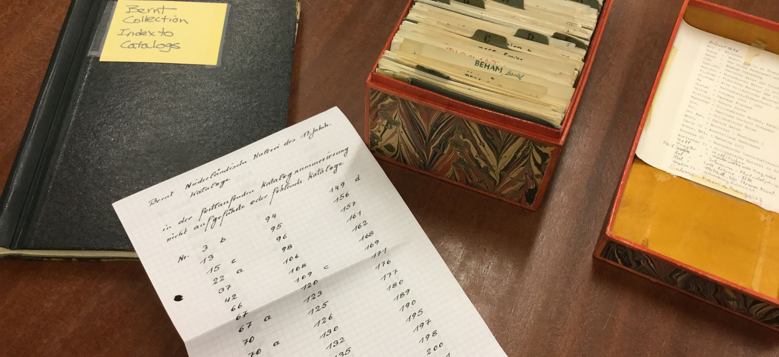 Color photograph showing Inventory sheets, notebooks, and a box of card catalog placed on a desk 