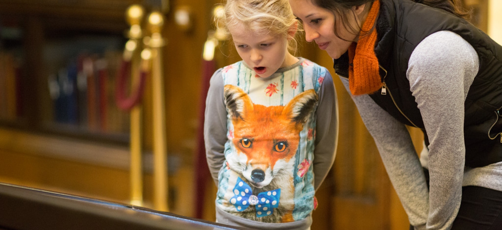 A scholar and her daughter look at the Gutenberg Bible in Harry's room. 