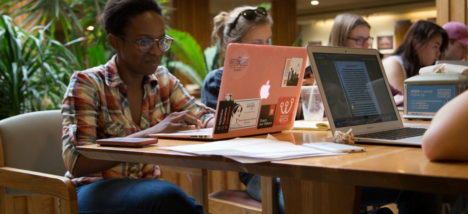 Peer Research Fellow Lisa Chille working on a computer around other students at a table