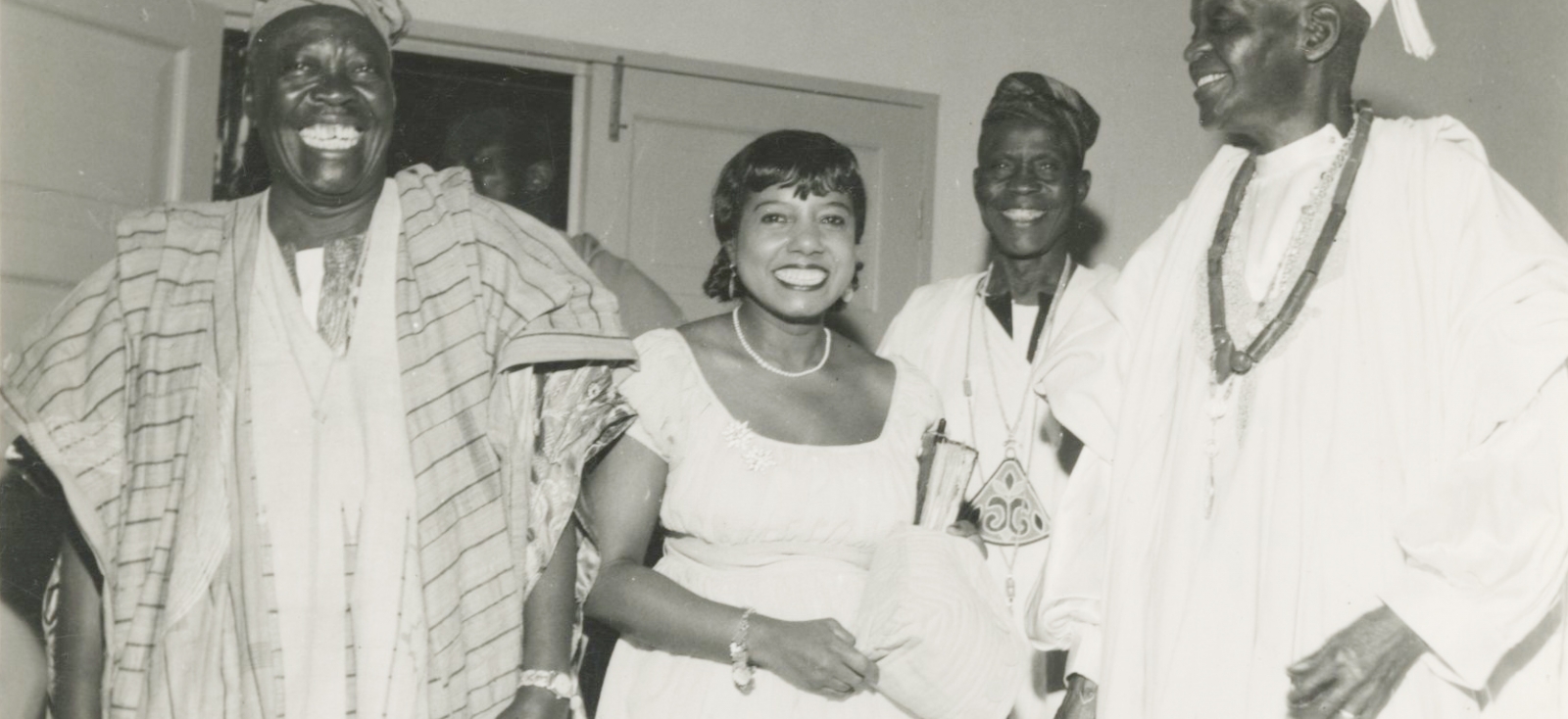 Marguerite Cartwright stands, wearing white, around a group of people