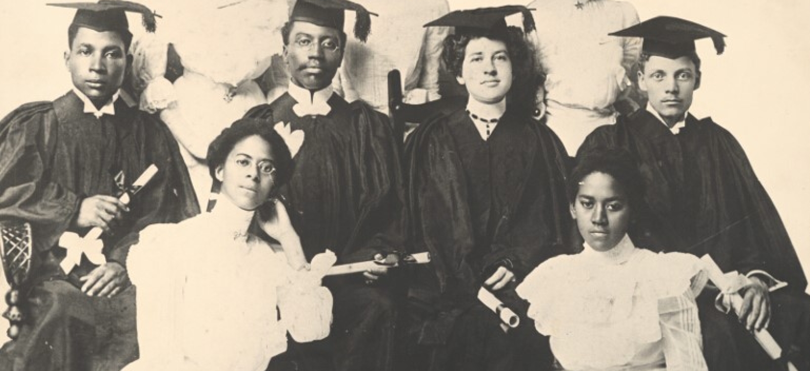Black and white photo of 9 African American students posed in graduation attire