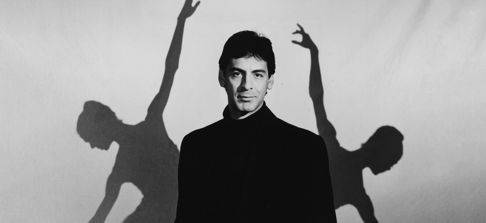 Jimmy Gamonet de los Heros flanked by two silhouetted dancers