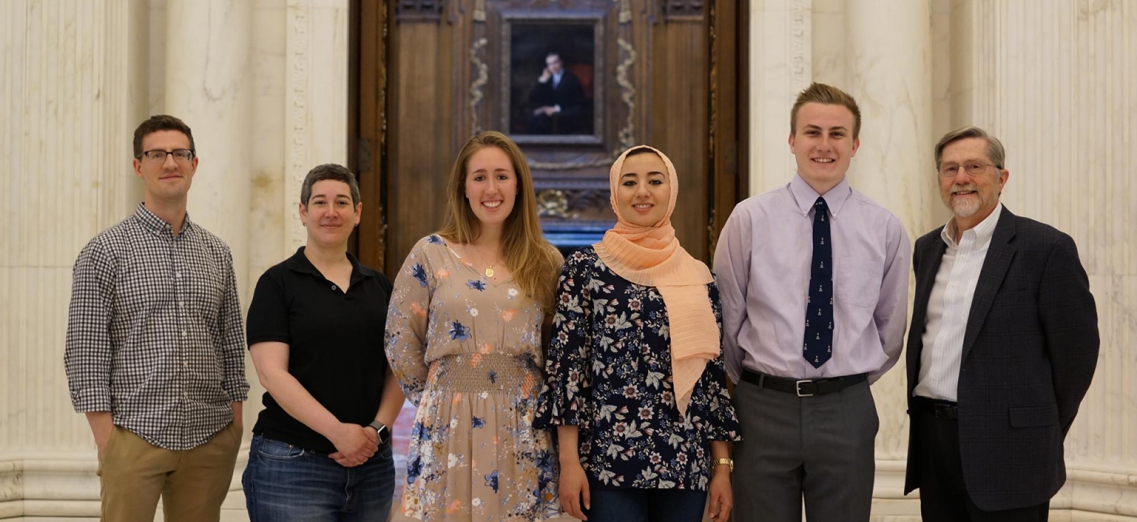 Winners of the Undergraduate Book Collecting Prize stand inside Widener and smile at the camera