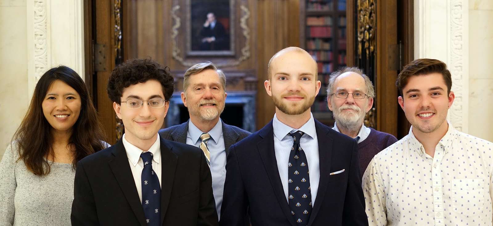 prize winners and judges standing side by side in the library