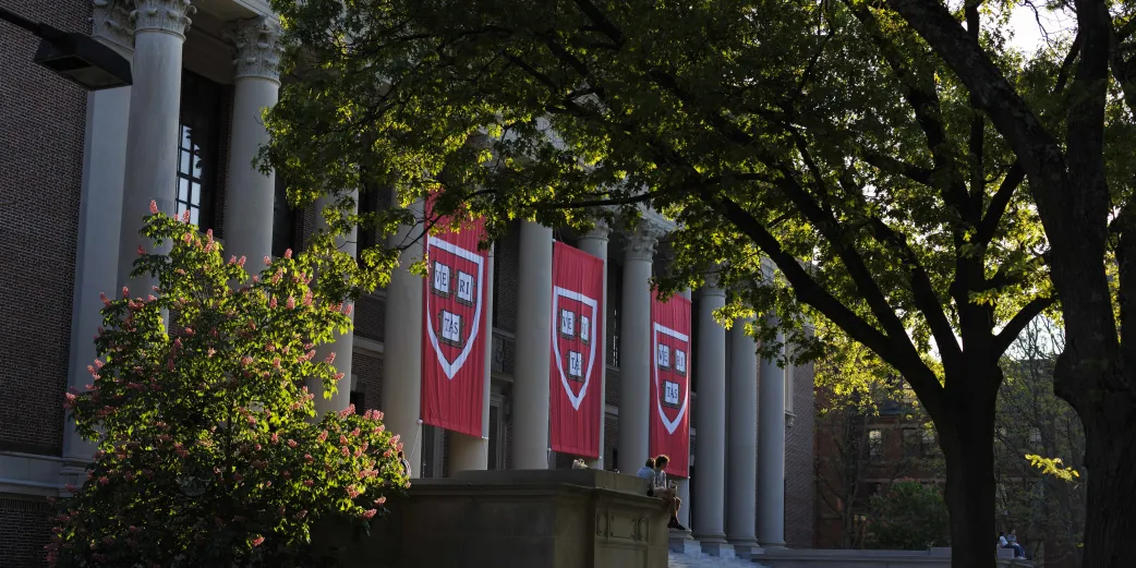 Banners with the Harvard shield hang from Widener Library