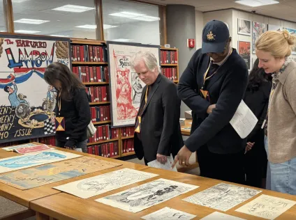 Visitors check out items from Harvard Lampoon pop-up exhibit at Harvard University Archives.