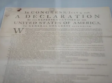 An image of the Declaration of Independence document on a blue background.