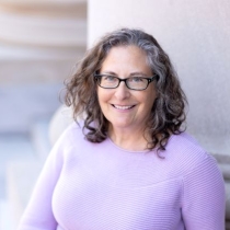 Picture of Spruill wearing glasses and a lavender sweater