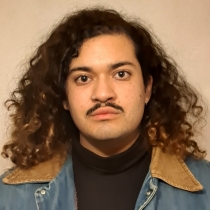 Front-facing photo of Mateo Caballero wearing a black turtleneck and a denim jacket