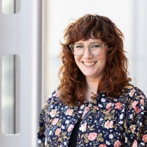 Professional headshot of Melanie Meents wearing blue floral jacket with white background