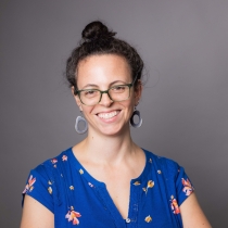 Headshot photograph of Blake Spitz, a white woman with glasses, and brown hair up in a bun.