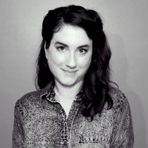 Colleen faces the camera and smiles. She has shoulder-length dark hair and blue eyes.